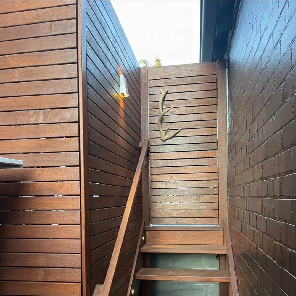 External timber stair between a brick wall and timber cladding