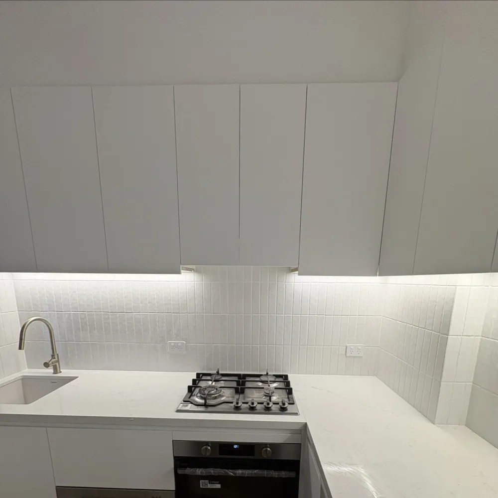 White kitchen with stone benchtop and gas cooktop