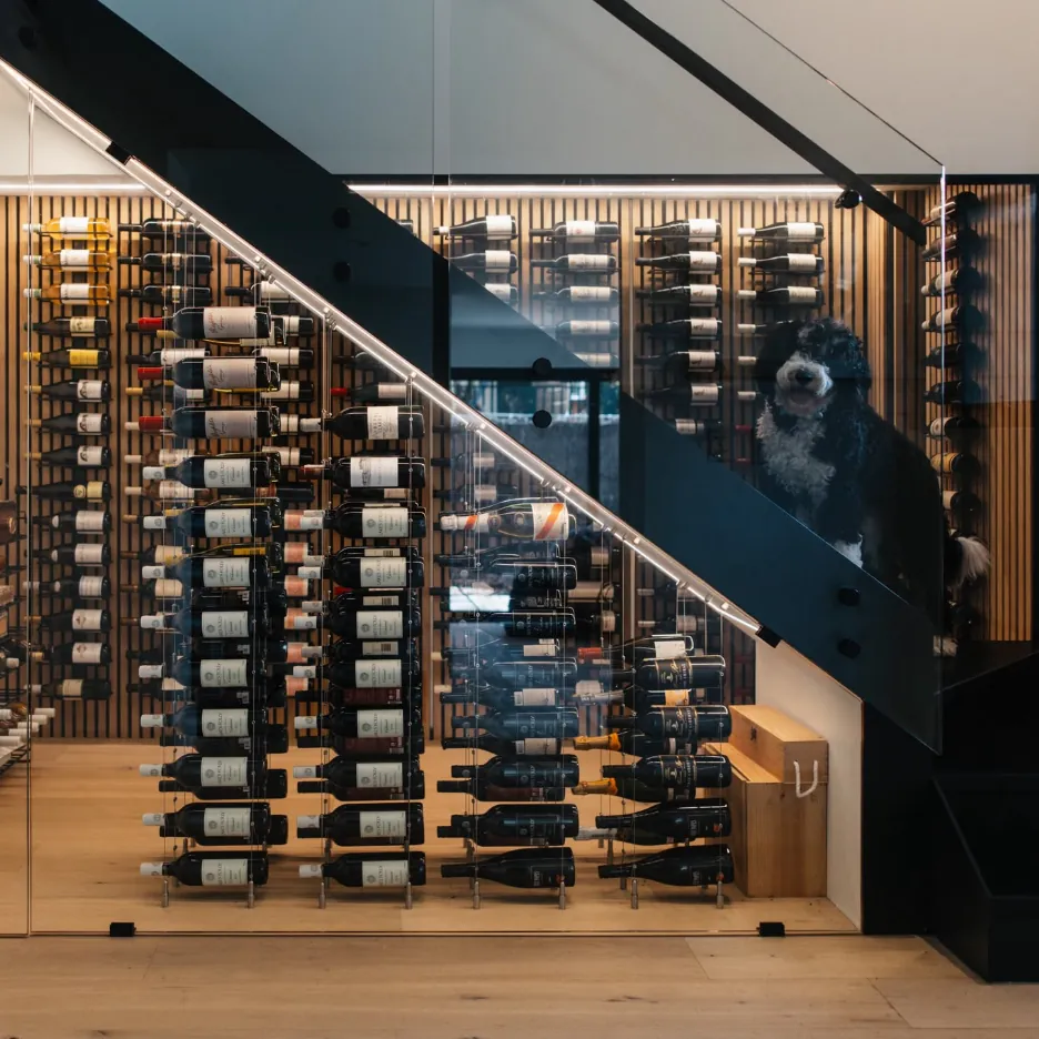 Glass-fronted wine cellar built under a staircase